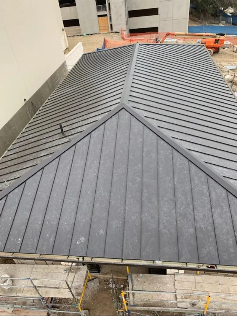 Commercial metal roof construction with crane equipment in Des Moines